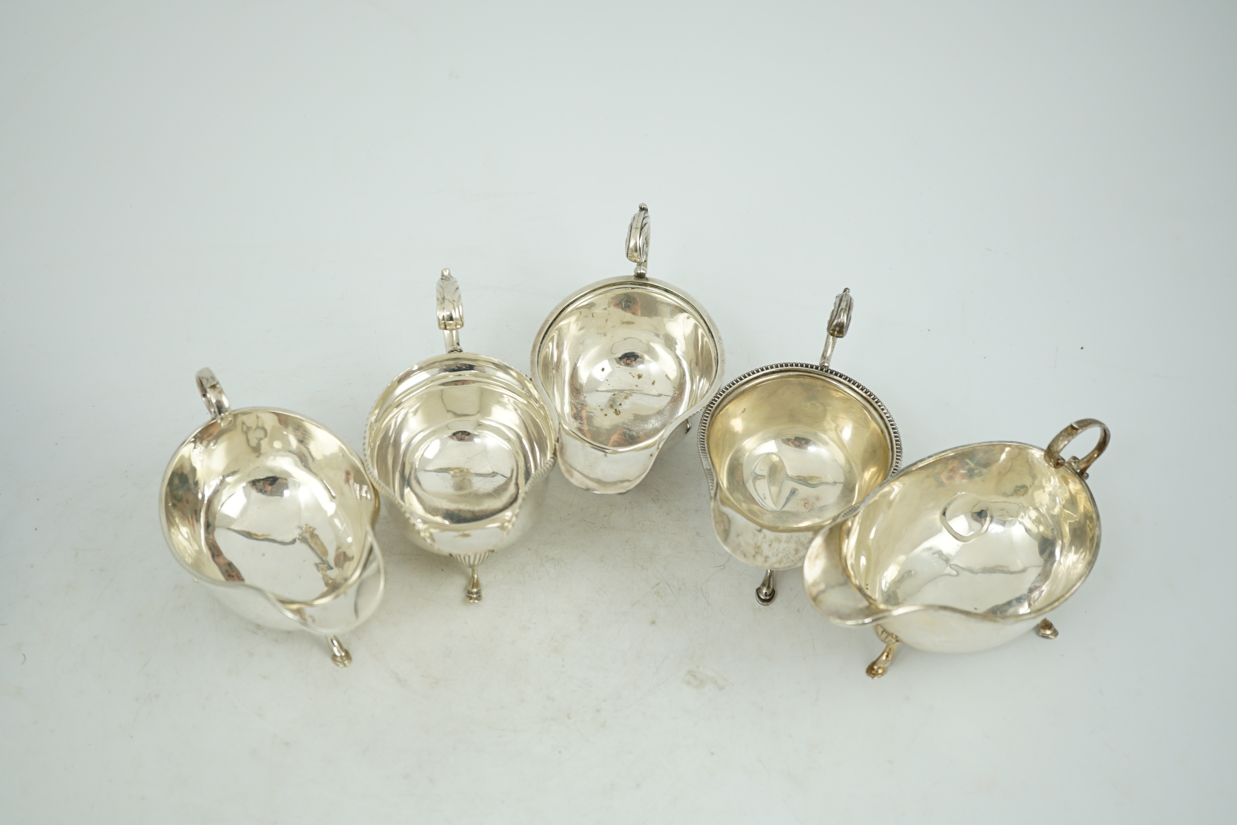 Five assorted early 20th century and later silver sauce boats, various dates and makers, 21.3oz.